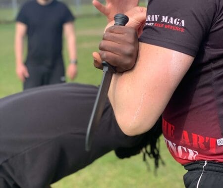 Martial artist practicing self-defense techniques during a high-energy training session